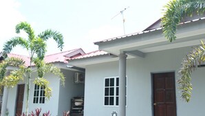 Filas de casas con techos rojos y paredes blancas, rodeadas de vegetación.