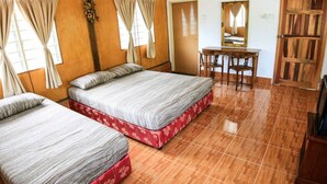 Una habitación con dos camas, un escritorio, una silla y un espejo.