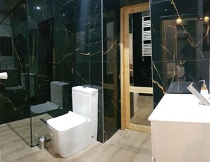 Bathroom features a white toilet, bidet, and sink with a mirror.