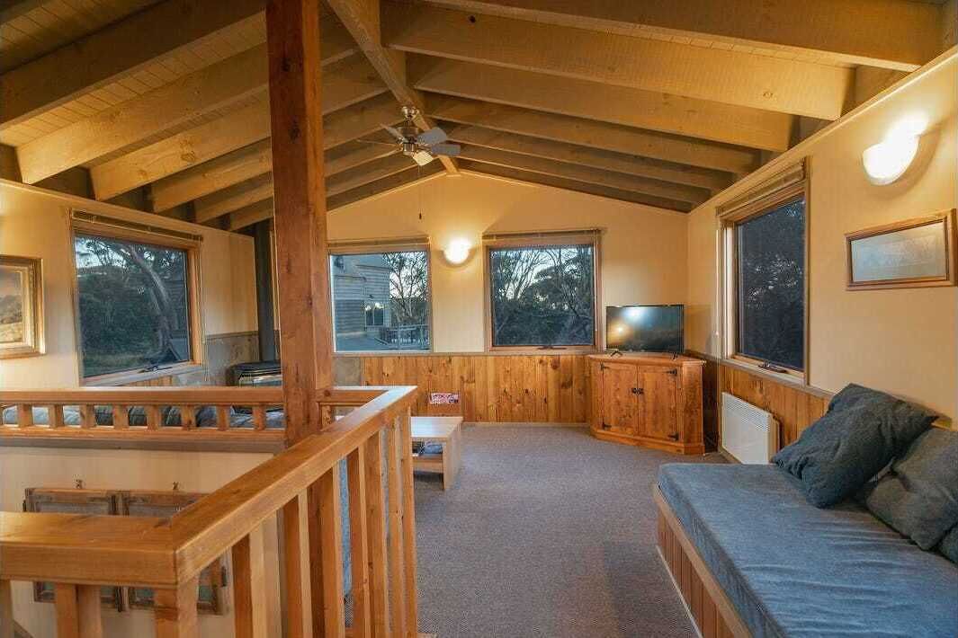 Een gezellig houten interieur met een bank, een televisie en een eethoek.