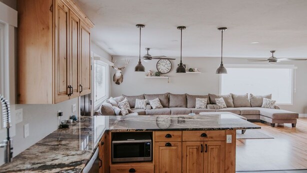 A modern kitchen with wooden cabinets, a granite countertop, and a built-in oven. - Country Farmhouse Sleeps 12 with hot tub. (Salmon)
