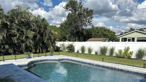 A rectangular swimming pool with clear blue water, surrounded by a white fence and lush greenery. - New Listing!! Gulf Coast beaches, 14 min to ManasotaKey, private heated pool! (Englewood)