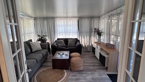 A living room with a sofa, a coffee table, and a side table with a plant. - New Listing!! Gulf Coast beaches, 14 min to ManasotaKey, private heated pool! (Englewood)