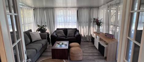 Una sala de estar con un sofá, una mesa de centro y una mesita auxiliar con una planta.