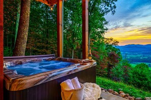 A hot tub set in a wooden deck with a view of a forest and mountains. - Secluded cabin | Epic mountain views + hot tub (Sevierville)