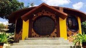 A small, rustic building with a circular window and a stone facade. - Taal Maranan Farmville Inc. (Taal)