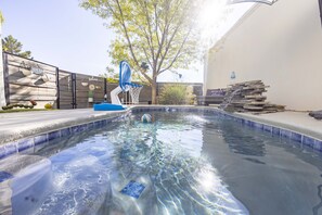 Une piscine bordée de carreaux bleus, un panier de basketball et un panneau indiquant « Piscine de détente ».