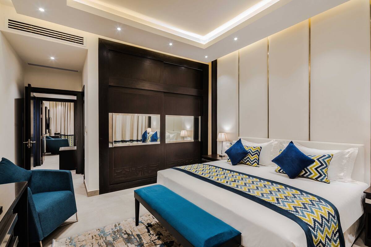 Une chambre d’hôtel moderne dotée d’un grand lit, d’un coin salon et d’un bureau séparé.