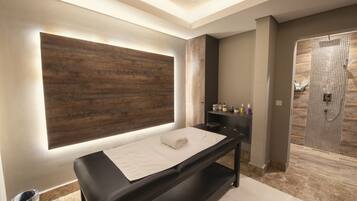 Relax in a serene spa room with a massage table, shower, and amenities.