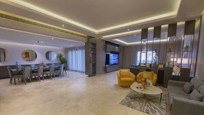 A modern living room with a dining area, a flat-screen TV, and a sofa. - Dorat Najd Resort (Diryah)