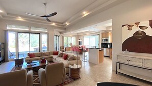 Un vaste espace de vie comprenant un canapé, une table basse et un ventilateur de plafond.