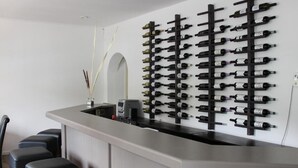 A bar area with a wine rack, stools, and a counter. - Spreezeit Hotel connect (Senftenberg)