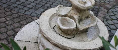 A stone fountain with a circular base and a central spout.