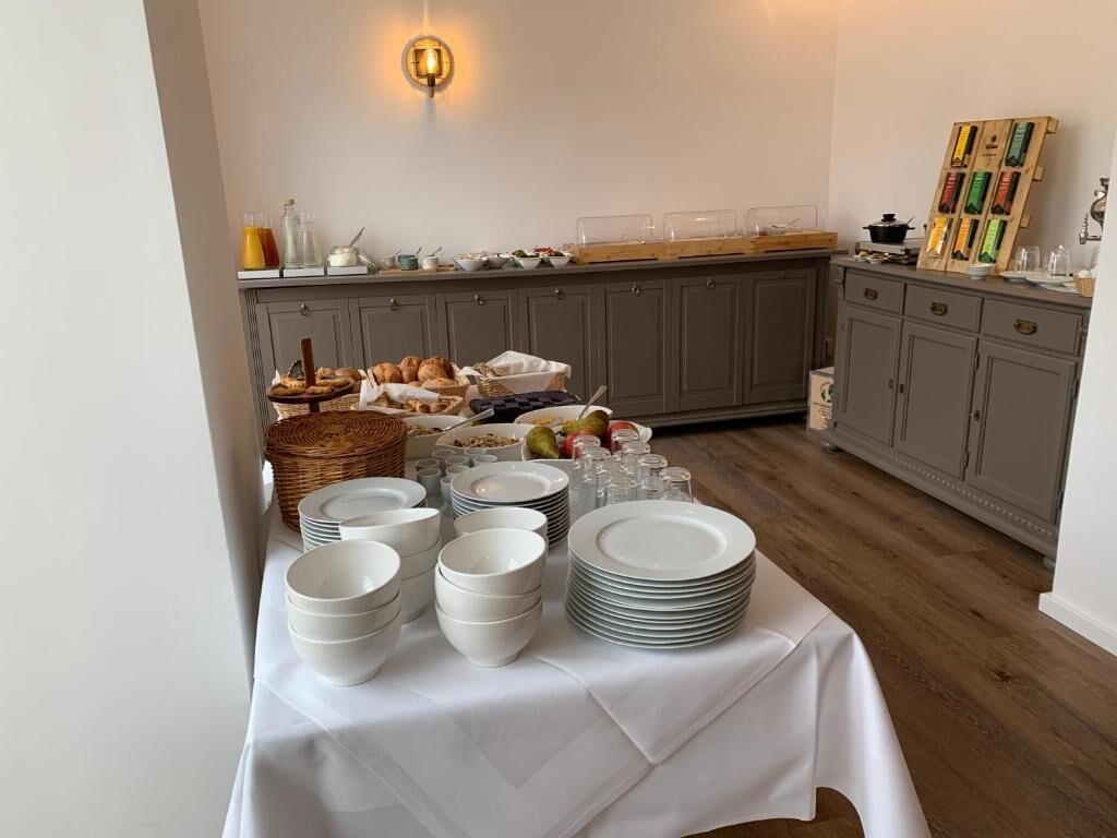 A breakfast buffet setup with various food items and dishes.