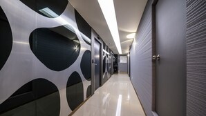 A modern hallway with reflective flooring and walls featuring geometric patterns. - Indeokwon Ian Hotel (Anyang)