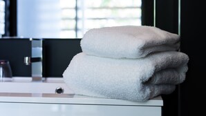 A stack of towels on a white counter in a bathroom. - Le Pavillon - The Lion (Néac)