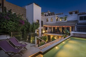 Een buitenzwembad en ligstoelen