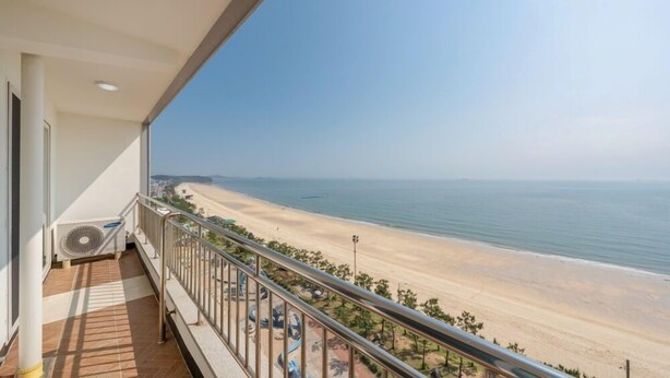 A balcony with a view of a beach and ocean. - Daecheon Mud Beach Hotel (Boryeong)