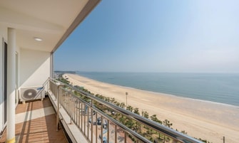 A balcony with a view of a beach and ocean.