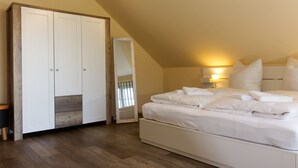 A bedroom with a large wardrobe, a neatly made bed, and a bedside lamp. - "Kleine Auszeit" Helle Ferienwohnung mit Balkon, mitten im Zentrum (Burg (Spreewald))
