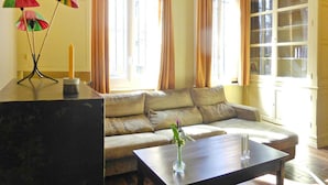 A living room with a sofa, a coffee table, and a bookshelf. - Apartment in Normandy near Pebble Beach (Fécamp)