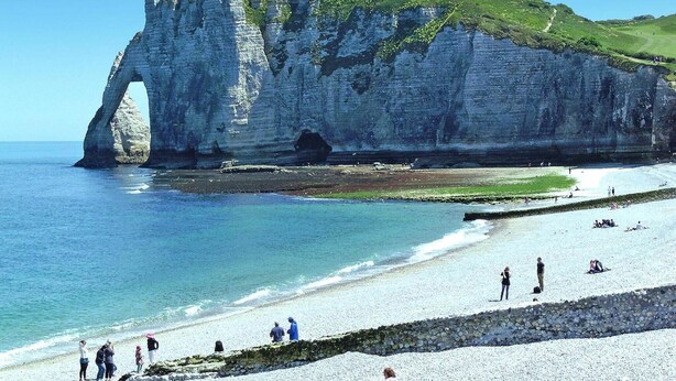 A coastal scene with a prominent white cliff formation and a beach with people. - Apartment in Normandy near Pebble Beach (Fécamp)