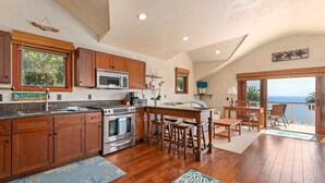 Une cuisine spacieuse avec des meubles en bois, un grand îlot central et une vue sur l’extérieur.