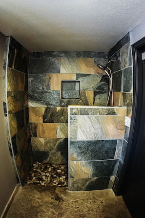 A shower with a stone wall and a picture frame. - Chamonix Retreat - Nearby Outdoor Activities! (Mammoth Lakes)