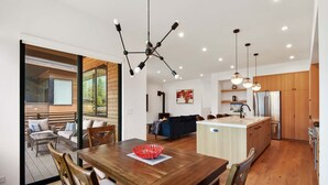 A modern kitchen with wooden cabinets, a stainless steel refrigerator, and pendant lighting. - Enjoy Paradise Hot Tub, Bike & Beach Equipment! (Olympic Valley)