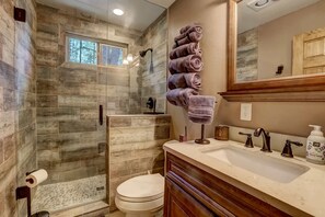 A bathroom with a shower, toilet, and sink.