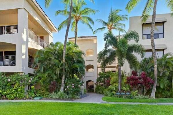 A hotel with a central courtyard, surrounded by lush greenery and palm trees. - Shores at Waikoloa Beach Resort 236 Golf Views (Waikoloa)