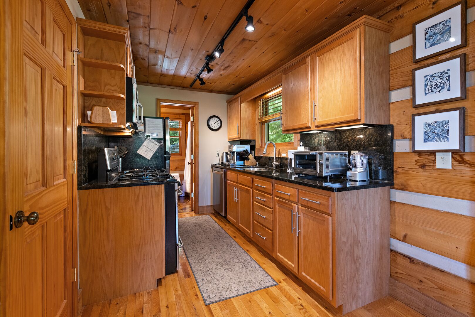 A kitchen with wooden cabinets, a stove, a microwave, and a coffee maker.