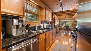Une cuisine moderne dotée d’appareils électroménagers en acier inoxydable, de meubles en bois et d’un grand îlot central.