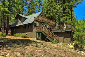 A cabin with a two-story deck and a steep staircase.
