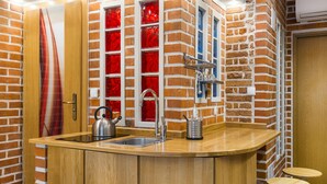 Une cuisine avec un plan de travail en bois, une bouilloire et un évier.
