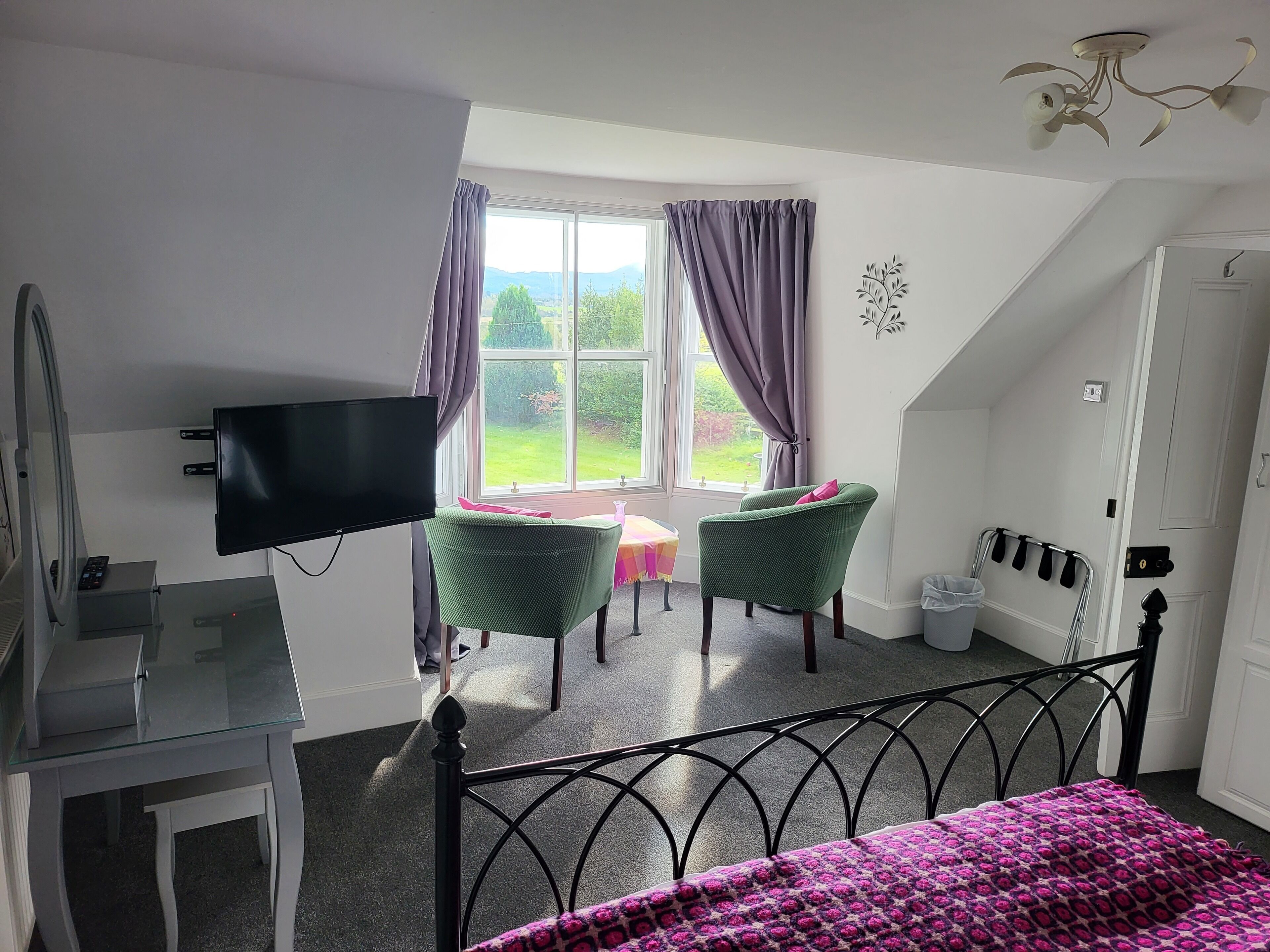 Une chambre à coucher avec un lit, une télévision, un bureau et une chaise.