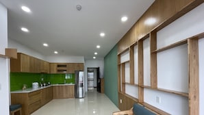 Una cocina moderna con armarios de madera, un refrigerador de acero inoxidable y un salpicadero verde.