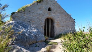 A stone building with a triangular roof and a barred entrance. - Holiday Home in Cléder near Les Amiets Beach (Cléder)