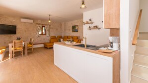 A compact kitchen with a central island, wooden cabinets, and a built-in oven. - Nice home in Stankovci (Stankovci)