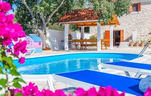 A swimming pool with lounge chairs, a children's playhouse, and a covered seating area. - Nice home in Stankovci (Stankovci)