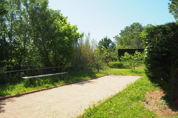 A gravel path leading to a fenced area with a bench.
