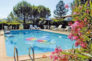 A swimming pool with lounge chairs and umbrellas.
