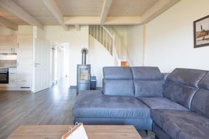 A modern living room with a grey sectional sofa, a wooden coffee table, and a fireplace.