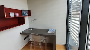 Ein moderner Arbeitsplatz mit Schreibtisch, Stuhl und Regale.