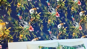 A bedroom with a bed, pillows, and a wall with a tropical animal and plant pattern. - The Apartment is in a calm, quiet location at the Lake Balaton! (Keszthely)