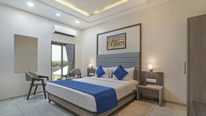 A modern hotel room with a large bed, bedside tables, a chair, and a view of the outdoors. - Sterling Gir (Mendarda)