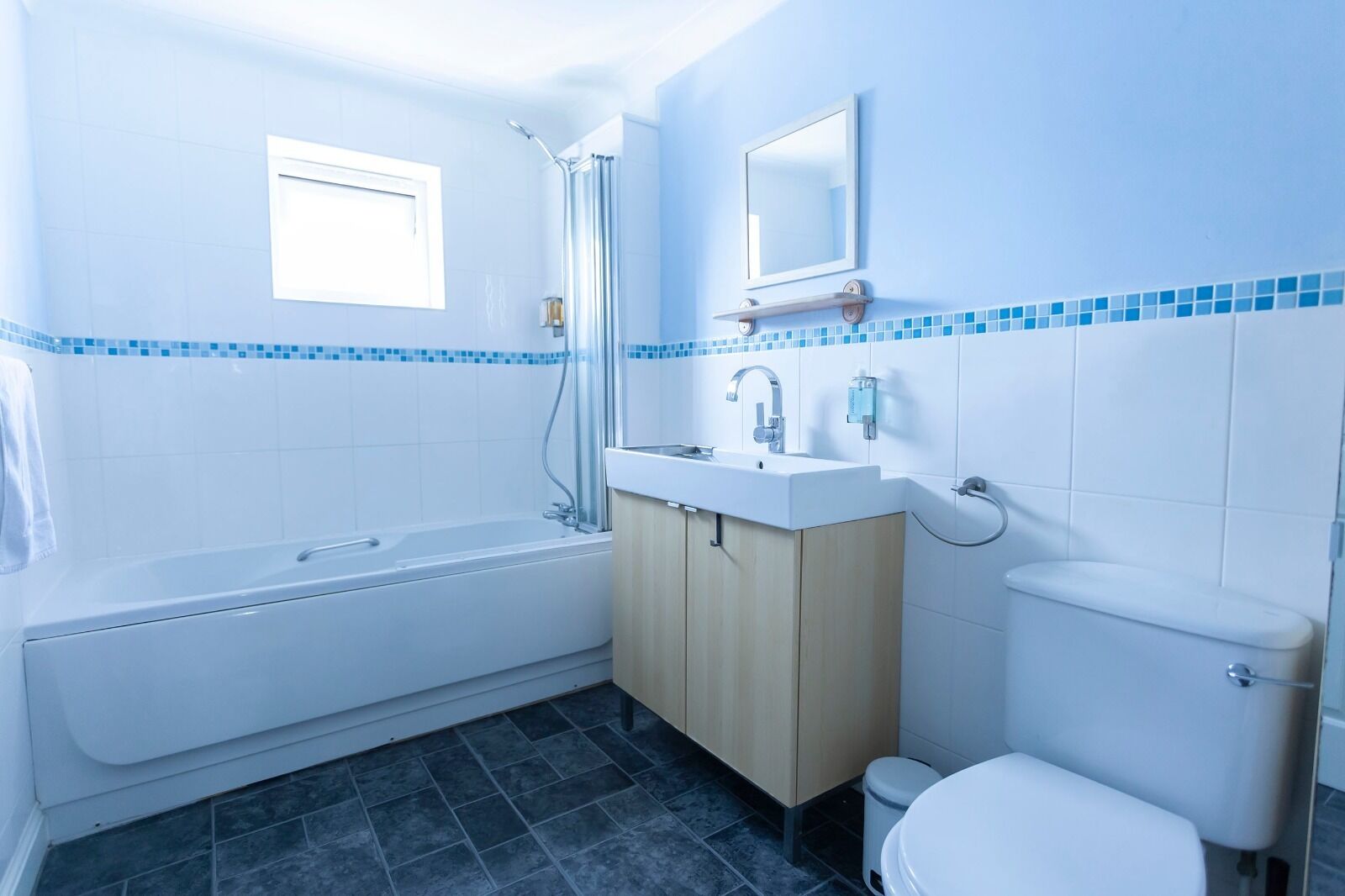 A modern bathroom with a bathtub, sink, and toilet.