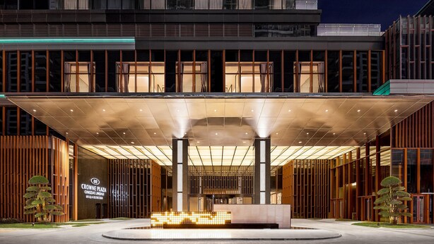 A modern hotel entrance with a covered walkway, large windows, and a prominent sign. - Crowne Plaza Qingdao Jinshui by IHG (Qingdao)
