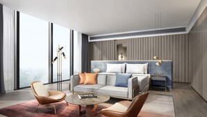 A modern hotel room with a large bed, a sofa, two armchairs, a coffee table, and a floor lamp. - Crowne Plaza Qingdao Jinshui by IHG (Qingdao)