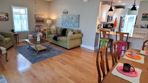A spacious living room with a dining area, wooden flooring, and a ceiling fan. - Large Luxury 4 bed/3 bath Beach House-2 Blocks to beach, 1 Block to Bay (Colonial Beach)